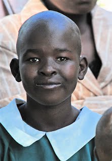 The girl in the picture is Munanie Kathini. She is 13 years old. Her mother is a single parent. She has no job but does casual work. Munanie has communication difficulties and has very mild mental retardation. She keeps herself very neat and tidy. She is very jolly and ever smiling. Munanie Kathini